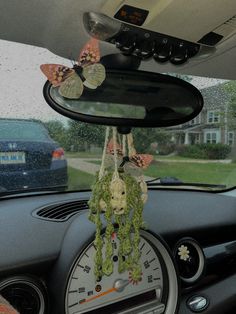 the dashboard of a car with butterflies hanging from it