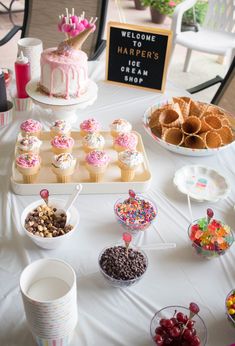 a table topped with lots of desserts and cupcakes on top of it