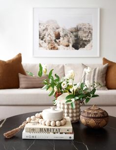 a coffee table with flowers and books on it