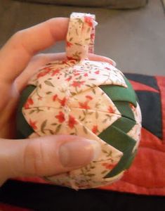 a hand holding an ornament that looks like it is made out of fabric