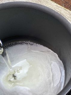 a pot filled with white liquid on top of a wooden table