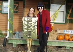 a man and woman standing in front of a house with pumpkins on the porch