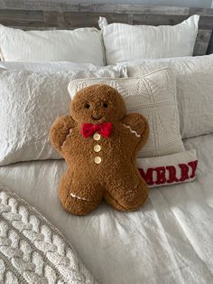 a brown teddy bear sitting on top of a bed