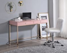 a pink desk with a laptop on it and a white chair in front of it