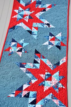 a quilted table runner with red, white and blue stars in the center on top