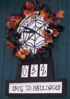 a clock decorated with leaves and flowers on the side of a building that says days to halloween