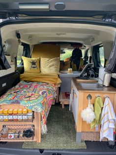 the interior of a van with two beds and an open trunk area in front of it