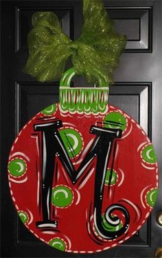 a christmas ornament hanging on the front door with a green bow around it