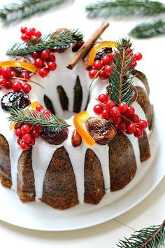 a white plate topped with a bundt cake covered in icing and fruit toppings