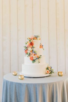 a white wedding cake with orange and blue flowers