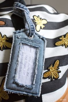 a black and white striped bag with gold bee patches on it's tag that says honeybees