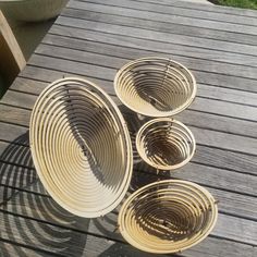 four wicker baskets sitting on top of a wooden deck