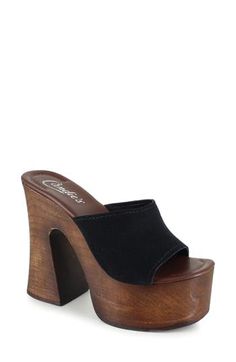 A woodgrain platform and soaring block heel lend scene-stealing height and retro-cool appeal to a slide sandal that will elevate your trendsetting looks. 4" heel; 2" platform Leather upper and lining/synthetic sole Made in Spain Black Chunky Platform Clogs For Summer, Wooden Platform Clogs, Wooden High Heel Sandals For Summer, Wooden Heels With Stacked Heel For Spring, Summer Wooden Stacked Heel Heels, Platform Wood Clogs With Block Heel, Open Toe Wooden Platform Clogs, High Heel Wooden Clogs For Summer, High Heel Wooden Platform Clogs