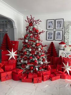 a christmas tree surrounded by red and silver presents