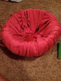 a pink chair sitting on top of a brown carpet