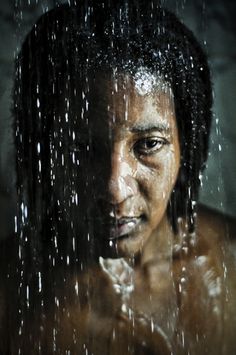 a man standing in the rain with his shirt open