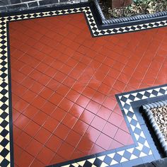 an orange and black tiled floor with some gravel