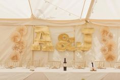 the table is set up with wine bottles and place settings for guests to sit at