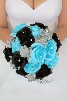 the bride is holding her blue and black bouquet