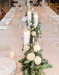 a long table with candles and flowers on it is set up for a formal dinner