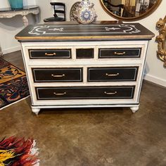 an antique dresser with black and white drawers