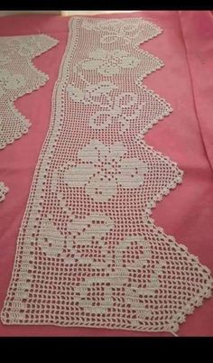 crocheted table runner on pink cloth with white lace and flower design in center