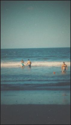 people are playing in the water at the beach