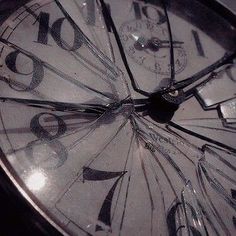 a close up of a clock face with broken glass on the bottom and numbers in the middle