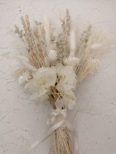 dried flowers are arranged on a white surface