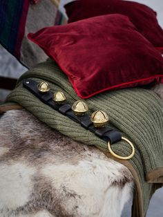 pillows and blankets are stacked on top of each other, with gold rings attached to them