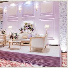 a living room filled with lots of furniture and flowers in vases on the table