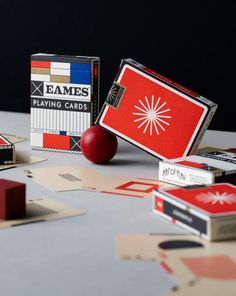 an assortment of playing cards sitting on top of a table next to a red ball