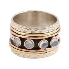 This ring by Shivani Choudhary in India is as meditative as it is beautiful. Circling the finger with a bold band of sterling silver this ring features four spinning segments of brass and copper that frame a sterling band that displays four rainbow moonstones. Spiritual Stackable Rings With Natural Stones, Bohemian Multi-stone Round Moonstone Ring, Bohemian Multi-stone Moonstone Ring, Spiritual Multi-stone Moonstone Ring, Jewellery Exhibition, Brass And Copper, Silver Spinner Rings, Spinner Ring, Wedding Idea