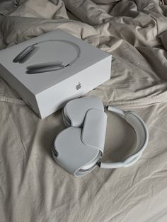 an apple product sitting on top of a bed next to a box and headphones