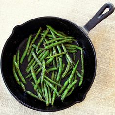 some green beans are cooking in a black skillet