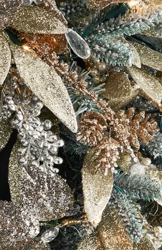 snowflakes and pine cones are covered in gold, silver and green tinsel