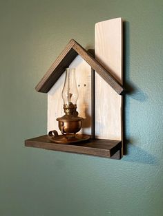 a house shaped shelf with a lamp on top and a light bulb in the middle