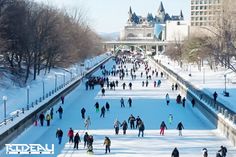 many people are walking in the snow near buildings