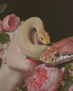 a woman with flowers around her head and a snake wrapped around her neck, in front of roses