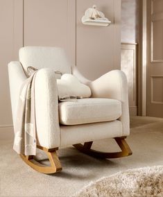 a rocking chair with a blanket draped over it's back in a living room