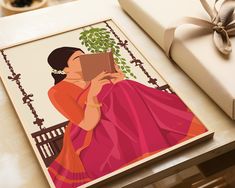 a woman sitting on a bench holding a book in front of her face and wrapped in a pink sari