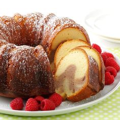 a white plate topped with a bundt cake and raspberries