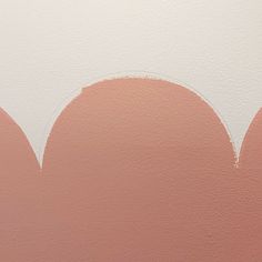 an orange and white painting on the side of a wall with circles painted on it