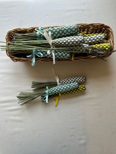 two baskets filled with green and yellow flowers on top of a white tablecloth covered floor