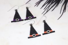 three black and orange beaded witch hats are hanging from earrings