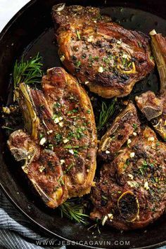 three steaks in a cast iron skillet with herbs