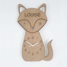 a wooden clock with the words louise written on it and a fox's face