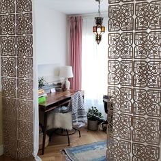 a room with a desk, lamp and curtains