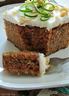 a piece of carrot cake on a plate with a fork and knife next to it