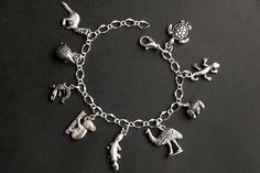 A collection of silver plated Australian wildlife themed charms have been dispersed around a shimmering silver plated bracelet chain in this handmade charm bracelet. This Australian wildlife charm bracelet is then completed with a lobster clasp and a 1/2 inch of chain at the end for adjustable sizing. Charms in this bracelet include a kangaroo charm, echidna charm, crocodile charm, koala charm, platypus charm, emu charm, wombat charm, gecko charm, and a sea turtle charm. ● Sizing ● To determine Nickel-free Silver Novelty Charms, Silver Novelty Charm Bracelet, Novelty Charms Bracelet Jewelry, Novelty Silver Hypoallergenic Charm Bracelet, Novelty Jewelry Charms Bracelet, Silver Novelty Metal Charm Bracelet, Novelty Silver Metal Charm Bracelet, Handmade Sterling Silver Dangle Charm Bracelet, Silver Metal Novelty Bracelets